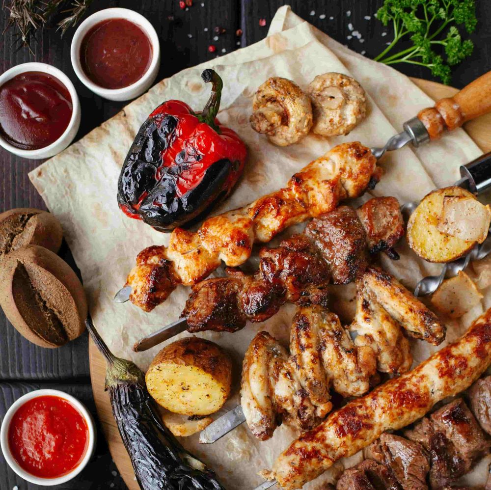 Eine Platte mit verschiedenem gebratenem Fleisch, Gemüse und Dips.